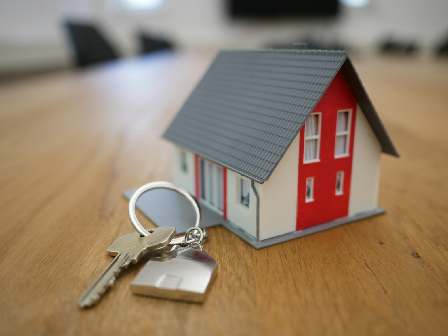 Model home on wooden table with keys and keychain